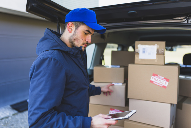 man-using-tablet-delivering-boxes_23-2147767576